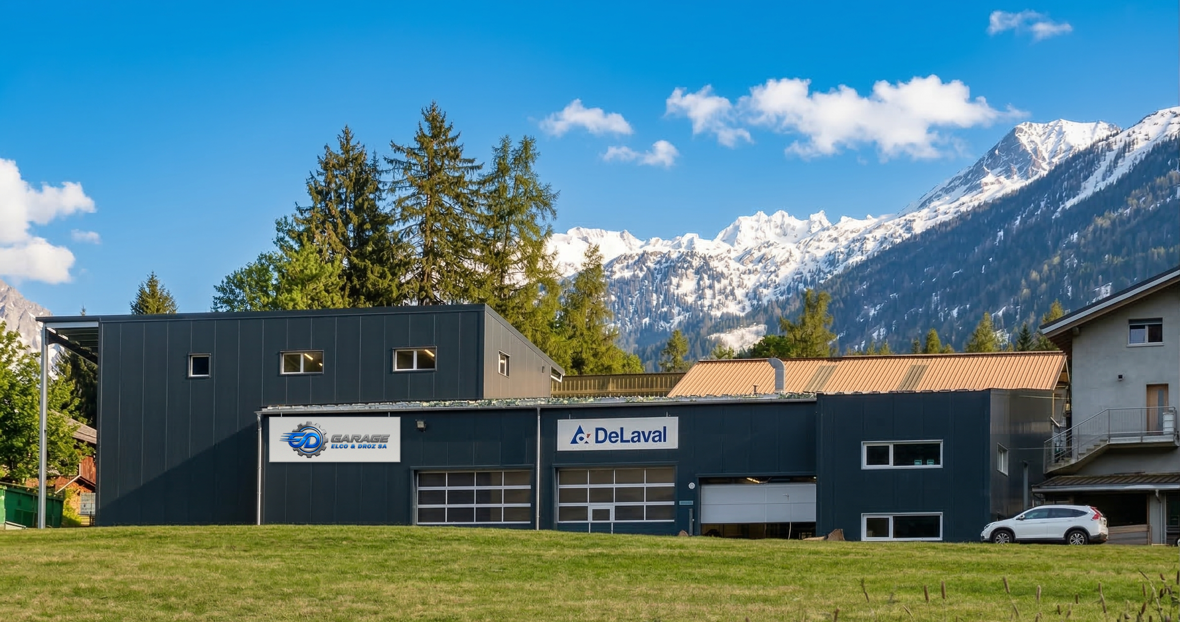 Le bâtiment du Garage Elco & Droz SA au Châble, avec les montagnes en arrière-plan